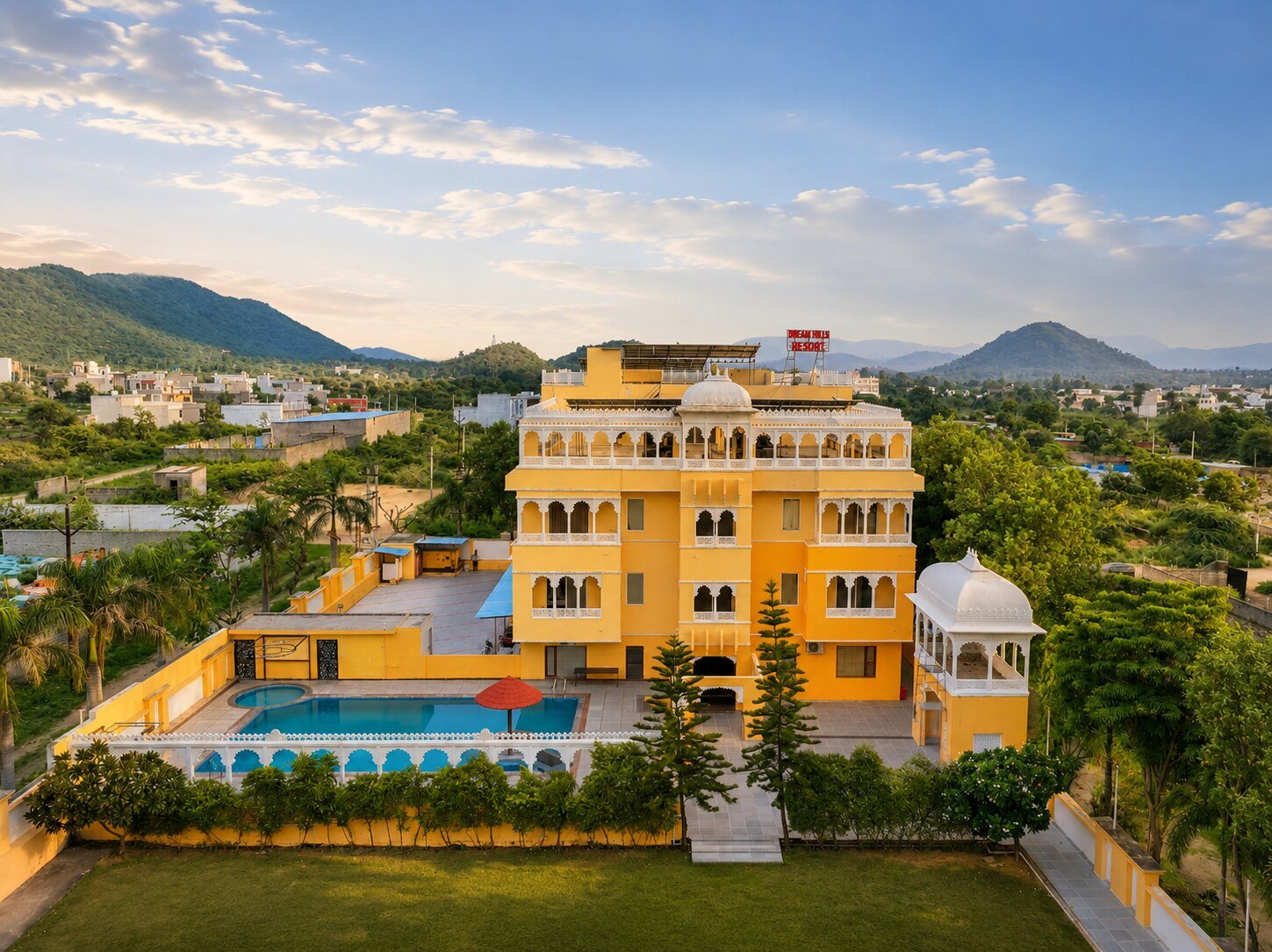 Aerial view of Dream Hills Resort against the Aravalli hills at sunset