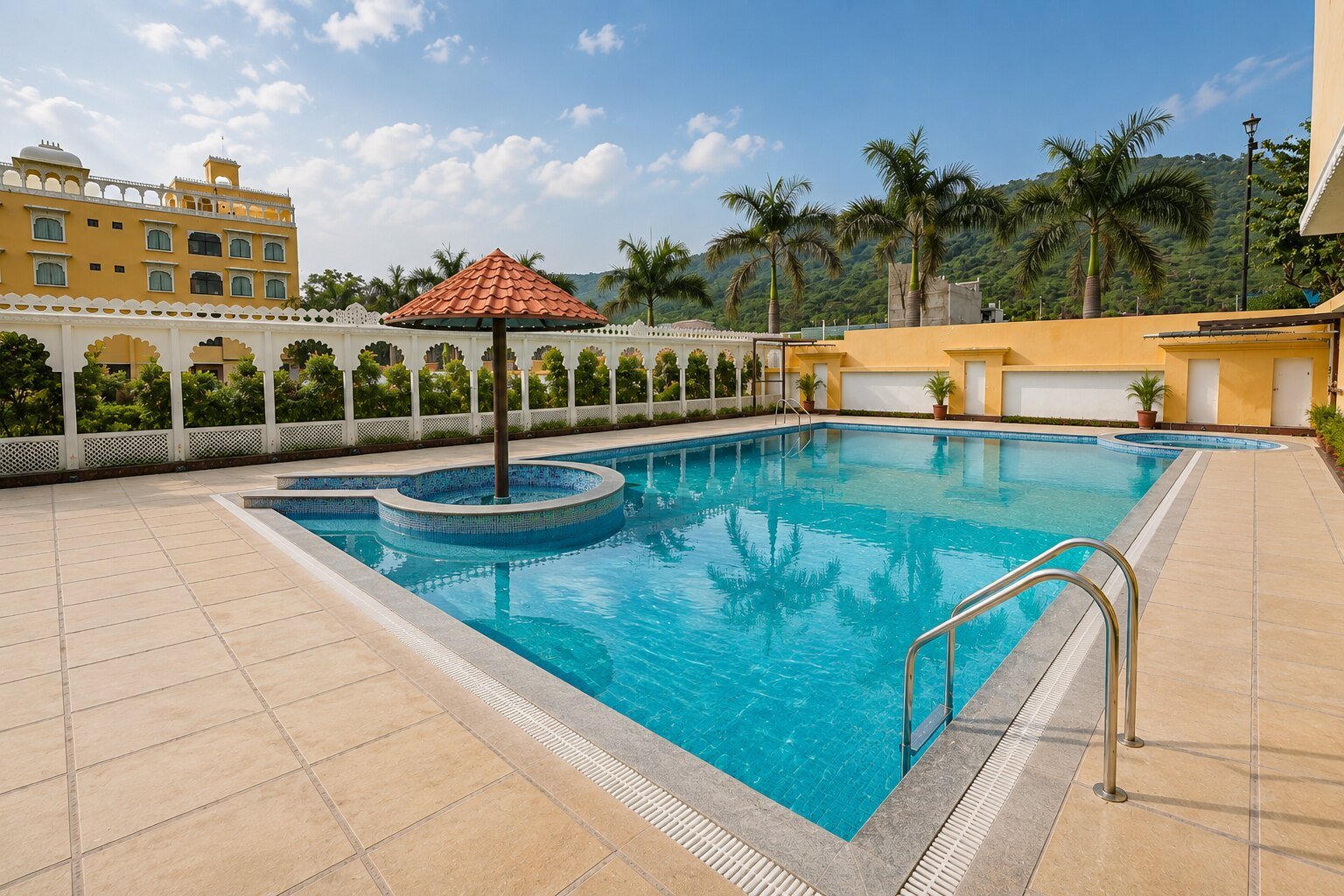The swimming pool at Dream Hills Resort framed by arched colonnades and palms