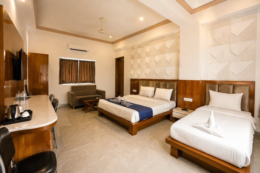 Premium Triple Room with textured headboard wall and seating